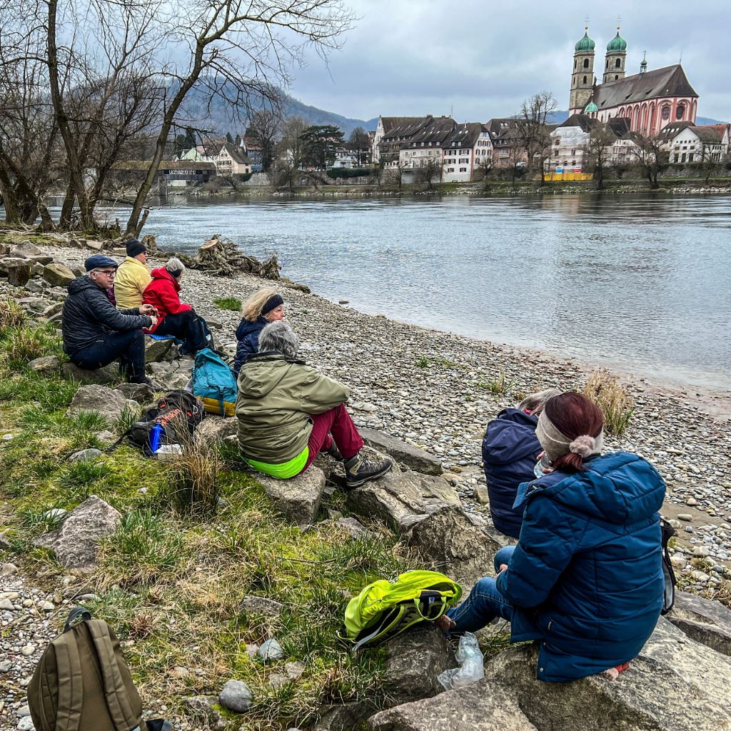 Die Wandergruppe geniesst die Mittagspause direkt am Wasser.