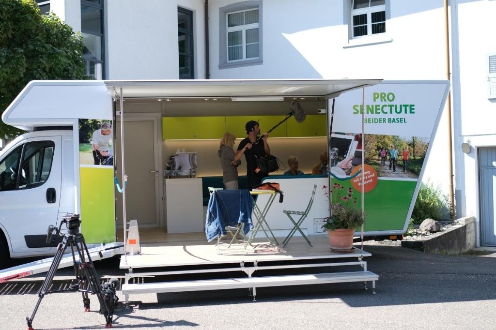 Im Infobus werden Aufnahmen von zwei älteren Personen gemacht.