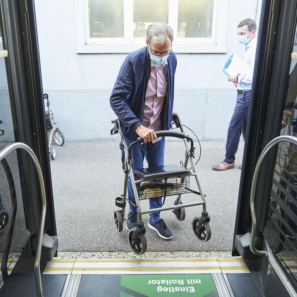 Senior mit Rollator steigt selbstständig in einen Bus ein.
