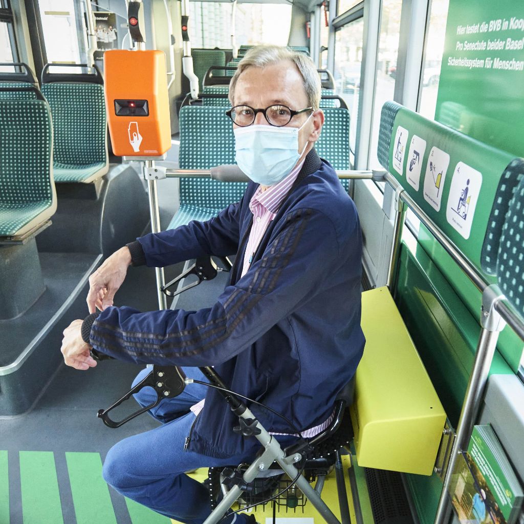 Senior sitzt in einem Bus auf seinem Rollator.