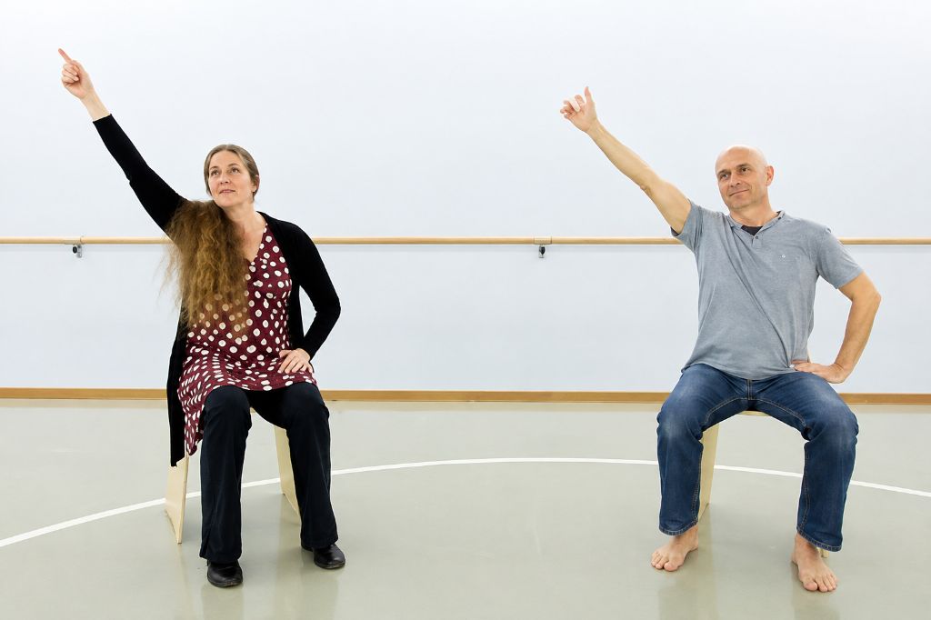 Personen unterschiedlichen Alters nehmen an einem Kurs zum Tanzen im Sitzen teil.