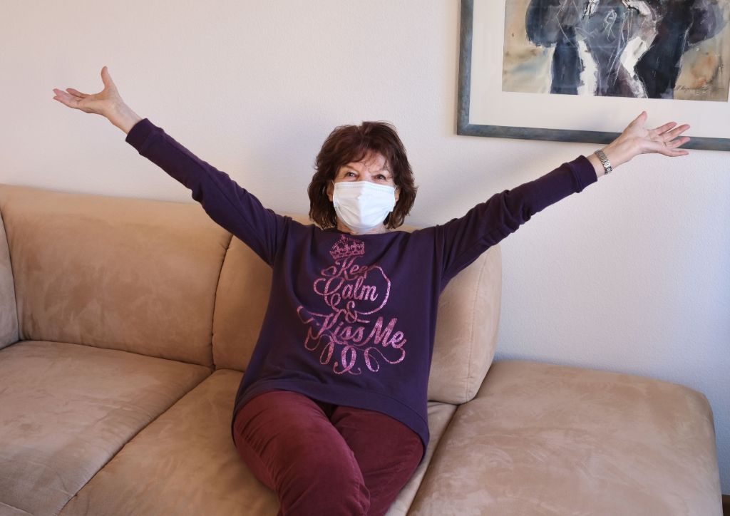 Zufriedene Seniorin sitzt nach einem Umzug auf ihrem Sofa.