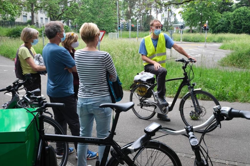 Personen unterschiedlichen Alters werden vom Kursleiter in den Gebrauch von E-Bikes eingeführt.