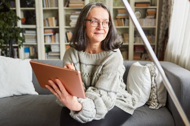 Eine ältere Dame bestellt ein Gratisexemplar vom Akzent Magazin.