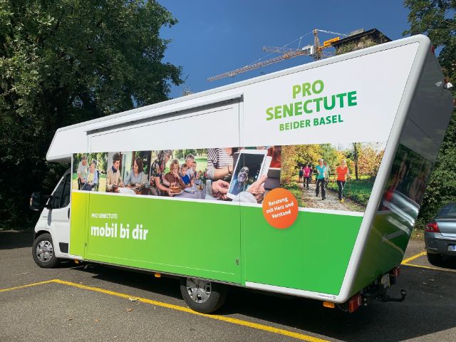 Infobus mit Leitsatz mobil bi dir hält auf einem Parkplatz.