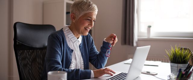 Eine Mitarbeiterin befindet sich vor ihrem Laptop und führt eine Unterhaltung.