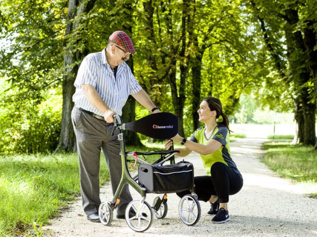 Mitarbeiterin erklärt einem Kunden seinen neuen Rollator.